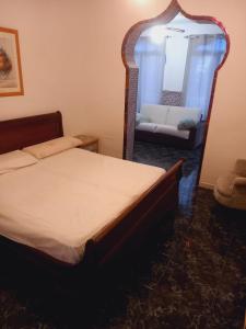 贝纳尔马德纳ESTRELLA LOUNGE的一间卧室配有一张床、镜子和一张沙发