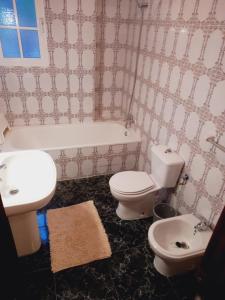贝纳尔马德纳ESTRELLA LOUNGE的浴室设有2个卫生间、水槽和浴缸。