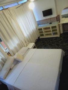 贝纳尔马德纳ESTRELLA LOUNGE的卧室配有一张大白色床和电视。