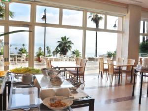天草市Hotel Alegria Gardens Amakusa - Vacation STAY 40451v的用餐室配有桌椅和大窗户