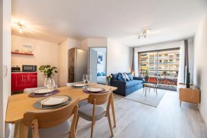 芒通Appartement cosy au centre ville de Menton的用餐室以及带桌椅的起居室。