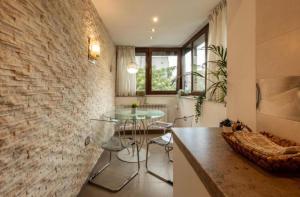 布加勒斯特Downtown Oasis Unirii Apartment的厨房设有玻璃桌和砖墙