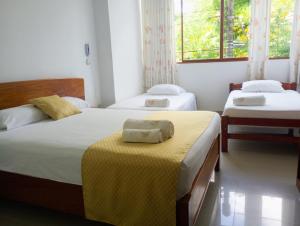 塔拉波托Posada del Angel Hotel的一间卧室设有两张床和黄色毯子