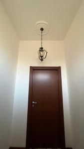 TerralbaCasa Corona - Appartamento affitto breve/lungo termine - casa vacanze的一间房间,上面有一扇门和一个吊灯