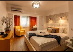 布加勒斯特Downtown Oasis Unirii Apartment的一间卧室配有一张大床和一张黄色椅子