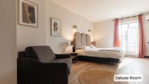 弗雷瑞斯Hôtel l'Arena的一间卧室配有一张床、一张沙发和一把椅子