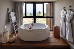 若昂佩索阿BA'RA Hotel的一间带大型白色浴缸和窗户的浴室