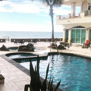 马萨特兰Ocean Front Condo sleeps 4 - on the Ocean - Marina View- Tiara Sands Resort的一座背景海洋的游泳池