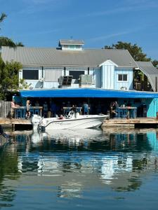 基韦斯特Aqua Lodges At Hurricane Hole Marina的停靠在码头的白色船,有一座建筑