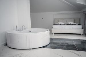 奥赫里德Delago的白色的浴室设有浴缸和床。
