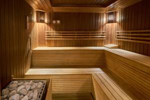 普列文普列文城市酒店的一间铺有木地板的木墙桑拿浴室和一个浴缸