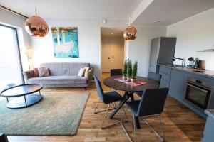 塔尔图R64 Premium Apartments的厨房以及带桌椅的起居室。