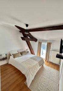 布隆Spacieux & Charmant 2 chambres - Lyon Bron Eurexpo的一间卧室设有一张带木制天花板的大床