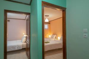 塞萨洛尼基Kassi Hanni Guesthouse的一间卧室配有两张床和镜子。