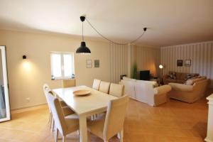 维拉摩拉Da Praia Apartment - Pool & Tenis的用餐室以及带桌椅的起居室。