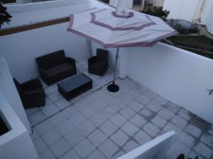 波尔蒂芒Huge Terrace Suite and 2 Balconies Portimao Center的庭院配有两把椅子和一把遮阳伞