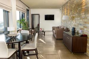 特里卡拉Ananti Resort & Spa的客厅配有桌子和砖墙