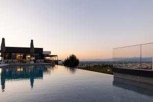 特里卡拉Ananti Resort & Spa的一座位于美景房屋屋顶的游泳池