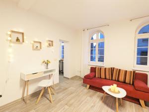 塞布尼茨Urlaubsmagie - Helle Wohnung mit Sauna & Pool & Whirlpool - F1的客厅配有红色的沙发和桌子