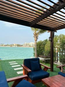 杜拉特阿拉尔فيلا بشاطئ خاص ومسبح的一个带椅子和桌子的庭院和棕榈树