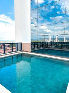 帕尔马斯Vivence Suítes Hotel Palmas的一座游泳池,位于一座享有城市美景的建筑内