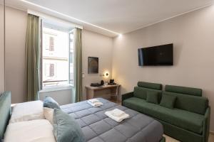 罗马IRON Luxury Rooms的客厅配有床、沙发和电视