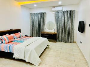 阿布贾Luxury Villa within Abuja Sanctuary的一间卧室配有一张床和镜子