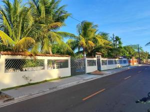 MarapanimCasa marudá的一条种有棕榈树和白色围栏的街道