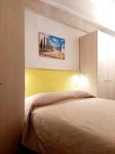 卡斯德尔诺沃贝拉登卡La casa di Elvira2的卧室配有一张床,墙上挂有绘画作品