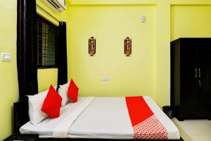 布巴内什瓦尔OYO Flagship Sri Balaji Guest House的一间卧室配有红色和白色枕头的床