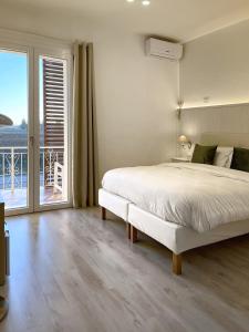 西尔米奥奈Villa Pensione Mercedes的一间白色卧室,配有床和阳台