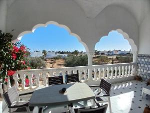 阿格希尔Menzel Churasco Djerba的美景阳台配有桌椅