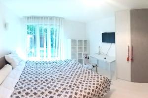 圣艾蒂安Appartement calme rez-de-jardin的白色卧室设有床铺和水槽