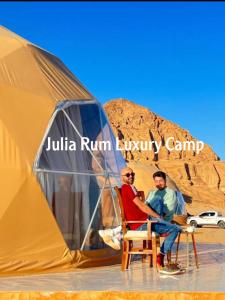 瓦迪拉姆Julia Rum Luxury Camp的两个男人坐在帐篷前