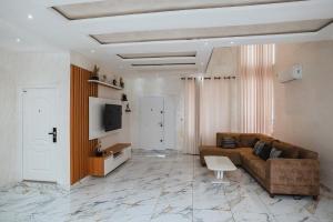 阿克拉Elegant and Cosy Four Bedroom Home in Accra的客厅配有棕色沙发和电视