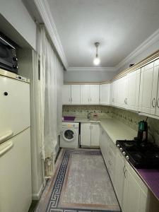 伊斯坦布尔Kadıköy Holiday Home的厨房配有白色橱柜和洗衣机。