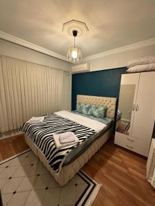 伊斯坦布尔Kadıköy Holiday Home的一间卧室设有一张蓝色墙壁的大床
