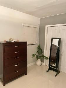 迈阿密Modern Miami Oversized 3 Bedroom in Central Location的一间卧室配有梳妆台、镜子和植物