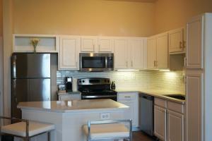 休斯顿New Apartment in Houston的厨房配有白色橱柜和不锈钢冰箱
