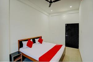 瓦拉纳西OYO Flagship Hotel Bhardwaj的一间卧室配有红色和白色枕头的床