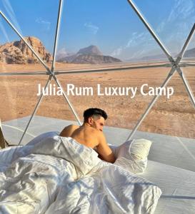 瓦迪拉姆Julia Rum Luxury Camp的躺在沙漠中的男人