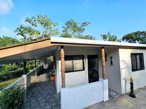 帕里塔Casa Cariad ,Home away from home by Playa Bejuco的白色的房子,设有木屋顶和门廊