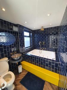 伦敦Jacuzzi Suite的带浴缸和卫生间的浴室。