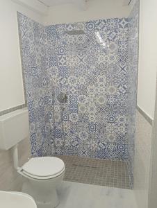 AnnunziataFree Zone的一间带卫生间的浴室和蓝色瓷砖墙