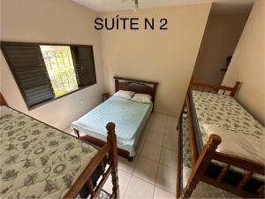 帕苏斯RANCHO SAPUCAÍ的一间卧室设有两张床和窗户。