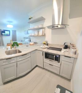 基西米Studio furnished的白色的厨房设有水槽和炉灶。