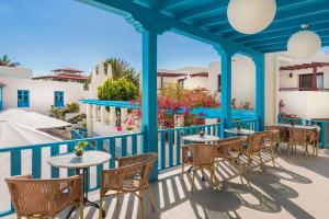 科拉雷侯Alua Suites Fuerteventura - All Inclusive的阳台的天井配有桌椅