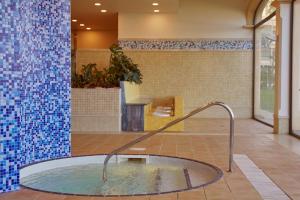 科拉雷侯Secrets Bahía Real Resort & Spa Adults only的蓝色瓷砖的房间内的热水浴缸