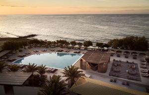 依拉佩特拉Numo Ierapetra Beach Resort Crete, Curio Collection Hilton的享有度假胜地的空中景致,设有游泳池和海洋