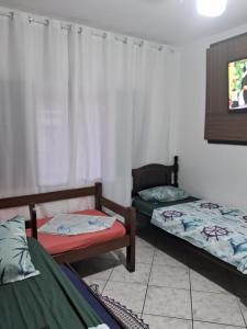 伊塔尼亚恩Hostel do Enzo的一间设有两张床和电视的客房